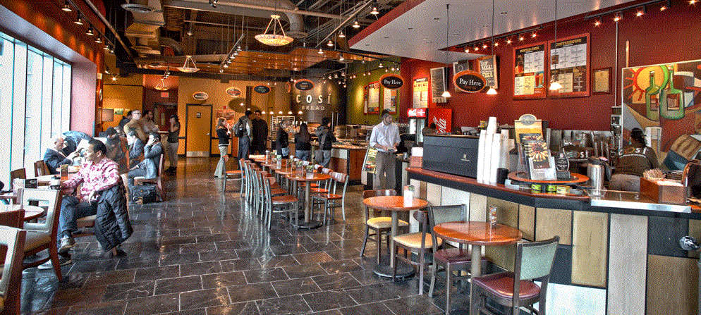 the interior of a restaurant with people sitting at tables